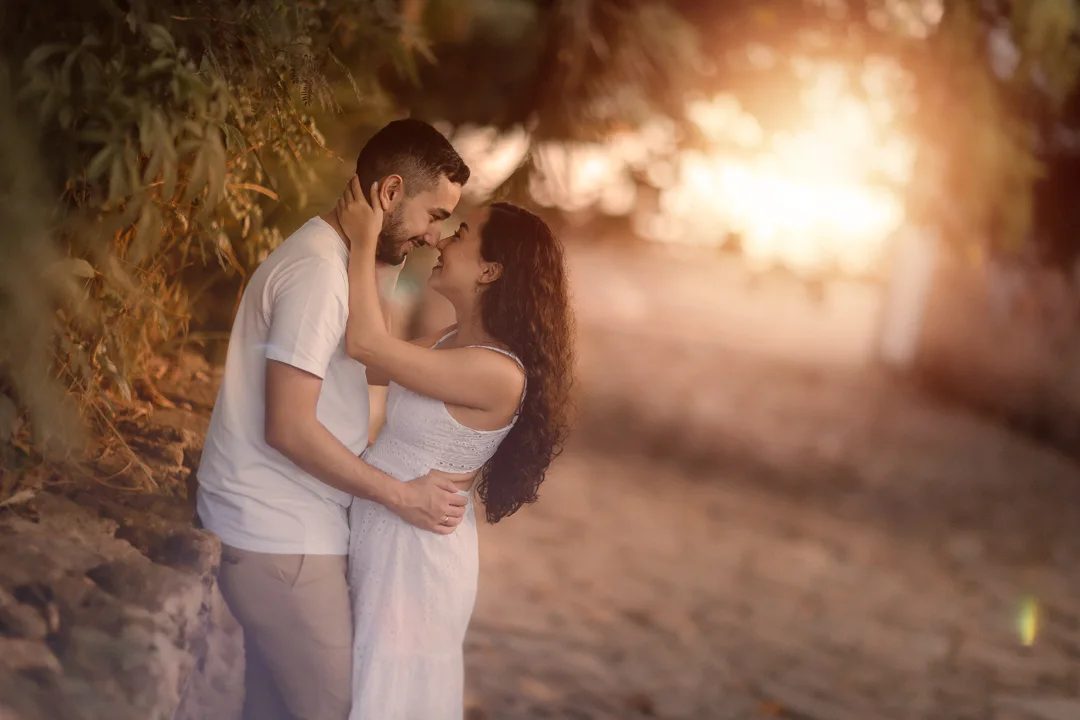 Casal em um abraço iluminado pelo pôr do sol